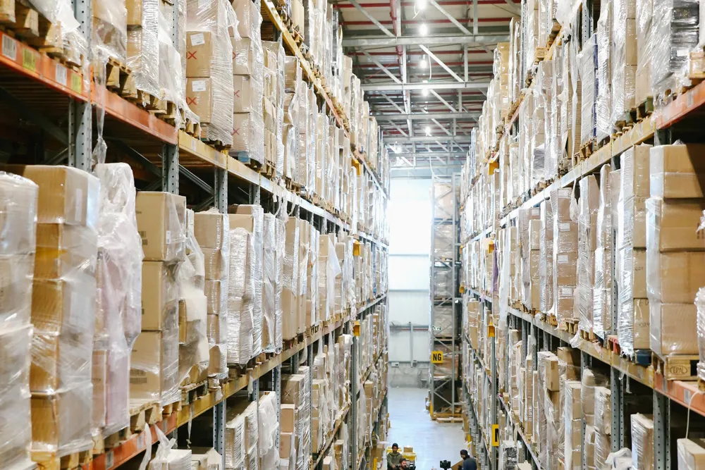 Illustrative warehouse: shelves with packed goods and a clear central aisle